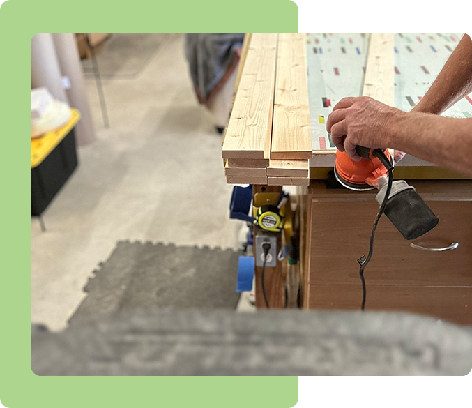 A person using an electric sander on wood.