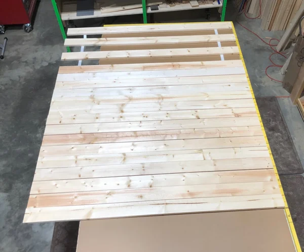 A wooden bed frame with some wood slats on it