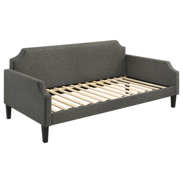 A gray couch with wooden slats on the bottom.