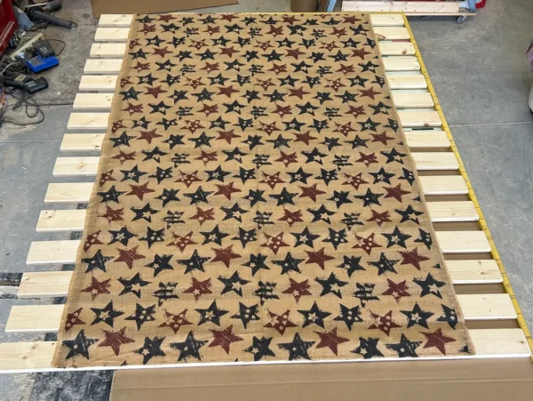 A bed with stars on it is made of wood.