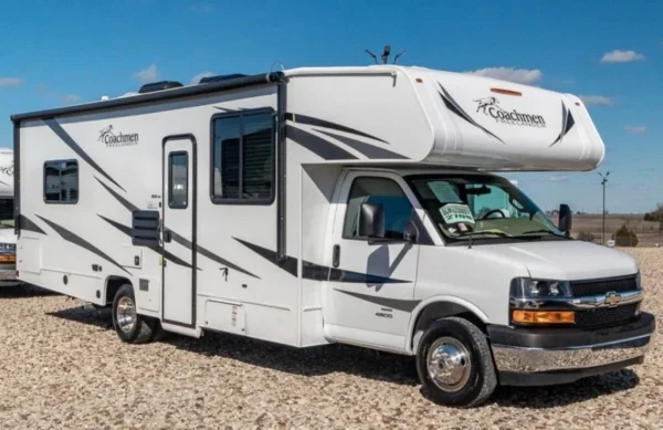 A white rv parked on top of a sandy beach.