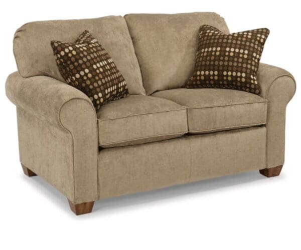 A loveseat with two pillows on it.