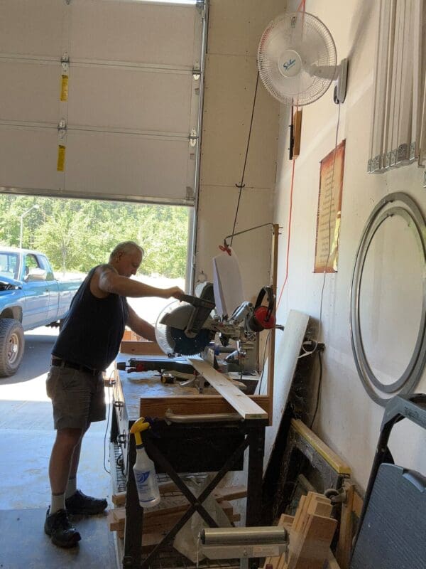 A man standing in front of a table with a saw.