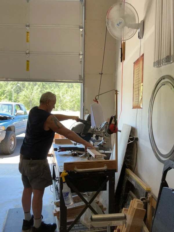 A man standing in front of a table with a saw.