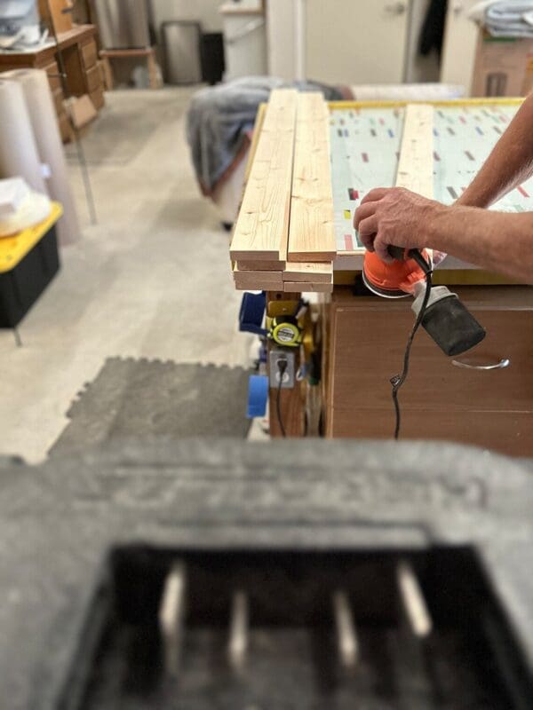 A person using an electric drill to build a bench.