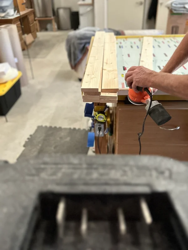 A person using an electric drill to build a bench.