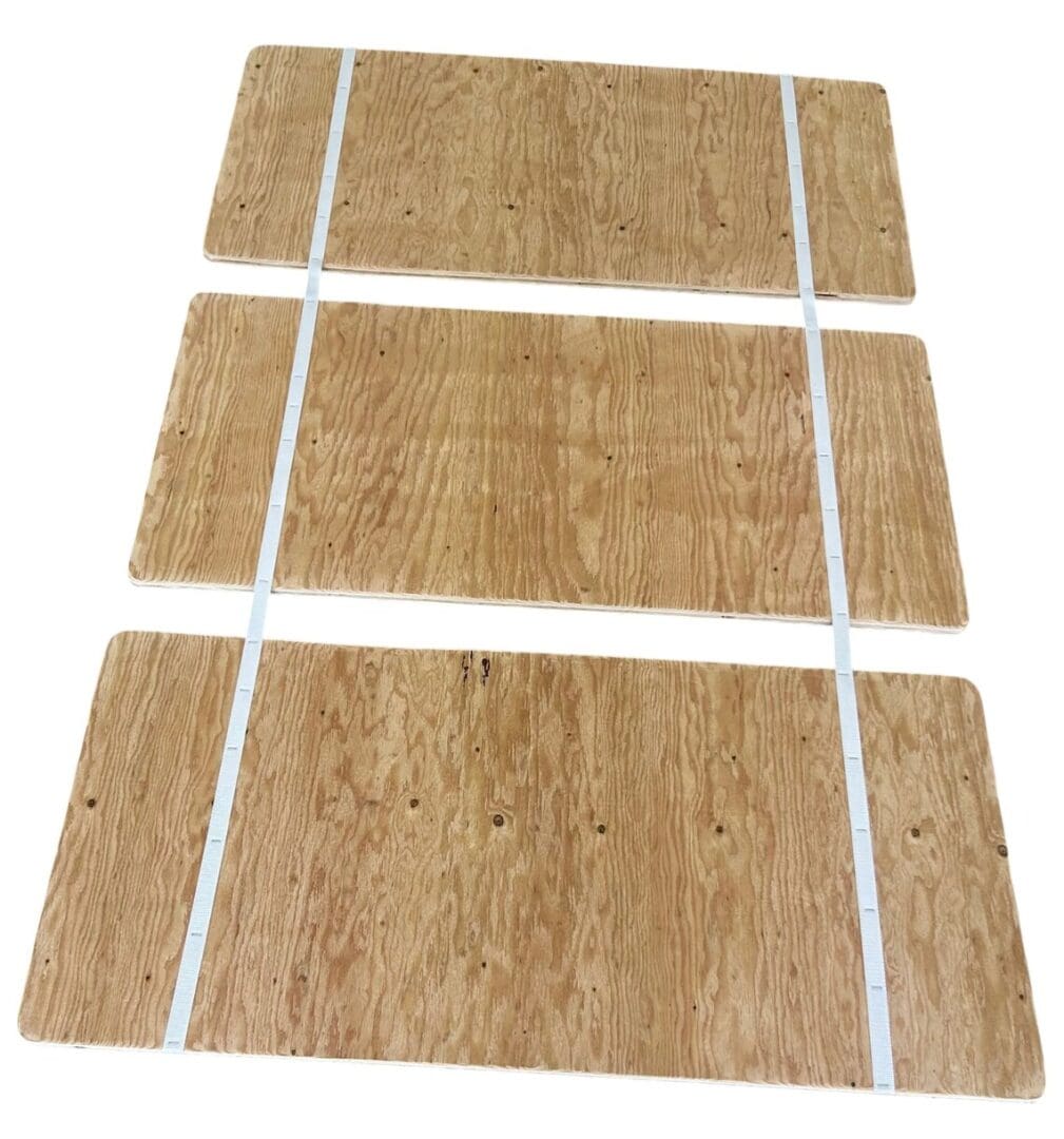 A set of three wooden boards with white tape.