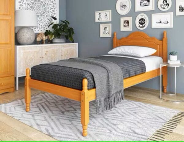 A bed with yellow wooden frame and headboard.