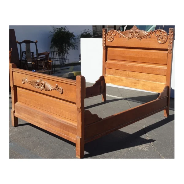 A bed frame with an ornate design on the headboard.