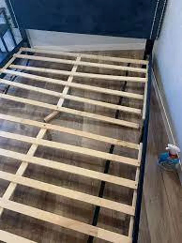 A bed frame with wooden slats on it.