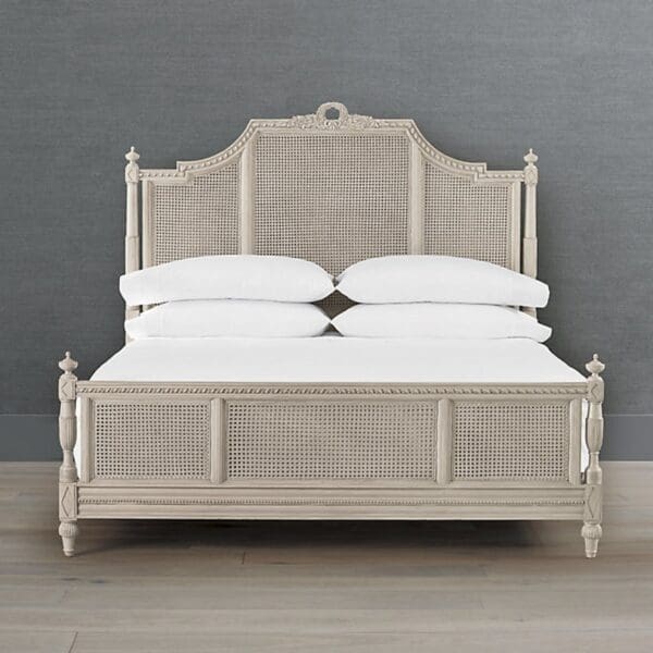 A bed with white sheets and headboard in front of a wall.