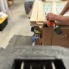 A person using an electric drill on top of a table.