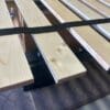 A bed frame with wooden slats and metal bars.
