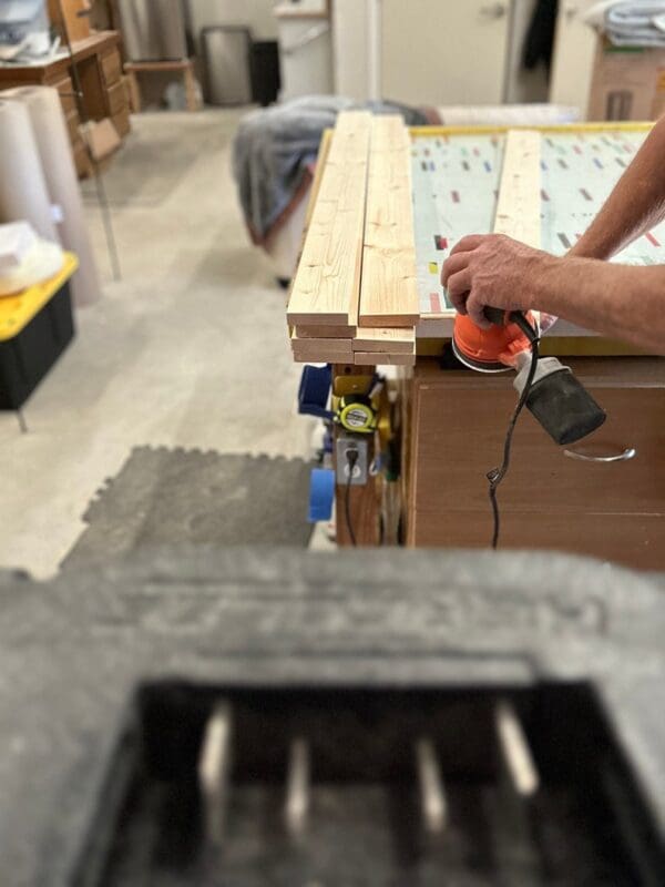 A person using an electric drill to build a table.